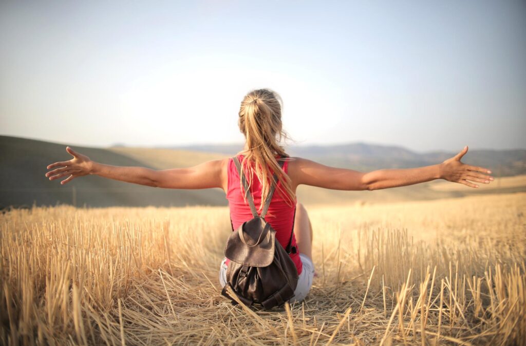 Woman with arms open in a wheat field
